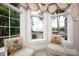 Bright sitting area with large windows showcasing the water view and adorned with elegant window treatments and comfortable chairs at 140 Lightship Dr, Mooresville, NC 28117