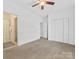 Empty carpeted bedroom with white walls, a ceiling fan, and an en suite bathroom at 140 Villa Lake Dr, Fort Mill, SC 29708