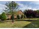 Charming brick house surrounded by trees, showcasing the beautifully landscaped front yard and well-maintained lawn at 140 Villa Lake Dr, Fort Mill, SC 29708