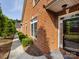 Side view of a brick house with a walkway, showcasing the architectural details and manicured landscaping at 140 Villa Lake Dr, Fort Mill, SC 29708