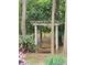Backyard swing set with chains hanging from wooden pergola nestled among the trees at 16134 Tinura Ct # 134, Tega Cay, SC 29708