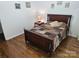 This is a warm and inviting bedroom with a beautiful hardwood floor and photographs on the wall at 16134 Tinura Ct # 134, Tega Cay, SC 29708