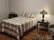This bedroom has hardwood floors, a decorative lamp on the nightstand, and a cozy patterned bedspread at 16134 Tinura Ct # 134, Tega Cay, SC 29708