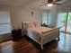 Well-lit bedroom with hardwood floors, a ceiling fan, and access to a deck at 16134 Tinura Ct # 134, Tega Cay, SC 29708