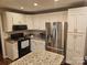 This is a kitchen with stainless steel appliances, granite countertops, and white cabinets at 16134 Tinura Ct # 134, Tega Cay, SC 29708