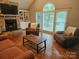 Open living room features a stone fireplace, built-in shelves, and large windows at 16134 Tinura Ct # 134, Tega Cay, SC 29708