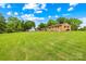 Spacious backyard with lush green lawn, backing onto a charming brick home with mature trees and ample space for outdoor activities at 1811 Belmar Dr, Gastonia, NC 28052