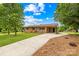 Charming one-story brick home featuring a cozy front porch, covered side entrance, and a spacious front yard at 1811 Belmar Dr, Gastonia, NC 28052