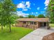 Traditional brick home features a covered parking area, well-kept lawn, and mature trees at 1811 Belmar Dr, Gastonia, NC 28052