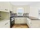 Bright kitchen featuring white cabinetry, black countertops, stainless steel appliances, and new floors at 1811 Belmar Dr, Gastonia, NC 28052