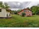View of a well-kept brick home's backyard, with a vintage storage building at 211 Amos Homesley Rd, Cherryville, NC 28021
