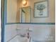 Modest bathroom featuring blue tile walls, a vanity, and a framed print of blue flowers above the toilet at 211 Amos Homesley Rd, Cherryville, NC 28021