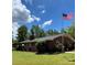 Charming brick home featuring a large, well-manicured lawn, American flag, and lush landscaping at 211 Amos Homesley Rd, Cherryville, NC 28021