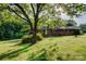 Well-maintained brick home featuring a lush, green lawn and mature trees providing shade at 211 Amos Homesley Rd, Cherryville, NC 28021