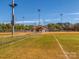 A well-maintained baseball field for residents to enjoy is surrounded by a chain link fence and trees at 2125 Belle Vernon Ave, Charlotte, NC 28210