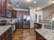 Well-equipped kitchen with stainless steel appliances, granite countertops, and dark wood cabinets at 2125 Belle Vernon Ave, Charlotte, NC 28210
