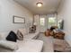 Cozy living room featuring neutral tones, comfortable seating, and natural light from the door at 2125 Belle Vernon Ave, Charlotte, NC 28210