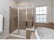 Enjoy the soaking tub and separate shower in this elegant main bathroom, enhanced by natural light at 2125 Belle Vernon Ave, Charlotte, NC 28210