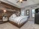 This main bedroom boasts a stunning wood accent wall, modern lighting, and tray ceiling at 2125 Belle Vernon Ave, Charlotte, NC 28210