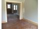 Living room area undergoing renovation, showcasing hardwood floors and doorway to another room at 216 N Rowan Ave, Spencer, NC 28159