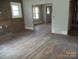 Open-concept living room with wood floors and multiple windows, awaiting personalization and renovation at 216 N Rowan Ave, Spencer, NC 28159