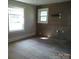 Bright living room featuring ample natural light and original wood paneling, ready for renovation at 216 N Rowan Ave, Spencer, NC 28159