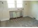 Room featuring a deactivated fireplace, surrounded by unfinished walls and bare floors at 216 N Rowan Ave, Spencer, NC 28159