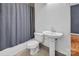 Clean bathroom featuring a white toilet, sink, and shower with neutral-toned tile and gray shower curtain at 226 Magnolia Ave, Charlotte, NC 28203
