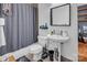 Bathroom featuring a shower, toilet, pedestal sink, and dark gray shower curtain at 226 Magnolia Ave, Charlotte, NC 28203