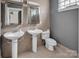 Tiled bathroom features pedestal sinks, dual mirrors, and modern toilet at 226 Magnolia Ave, Charlotte, NC 28203