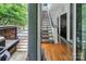 View from the patio door to a modern home entryway featuring hardwood floors and a striking staircase at 226 Magnolia Ave, Charlotte, NC 28203