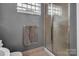Tiled shower with a glass door in a bathroom, accented by a towel rack and neutral wall color at 226 Magnolia Ave, Charlotte, NC 28203
