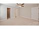 A bedroom features neutral walls, carpet, a ceiling fan and three doorways to a closet, bath, and entry at 2506 Glendale Ave, Kannapolis, NC 28081
