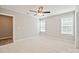 A neutral carpeted bedroom with two windows, a ceiling fan, and doorways to closet and bathroom at 2506 Glendale Ave, Kannapolis, NC 28081