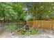 Landscaped backyard featuring a waterfall, plants, trees, and wood fence at 2617 Bay St, Charlotte, NC 28205