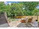Backyard with a wooden fence, a gas fire pit, and Adirondack chairs, creating a tranquil outdoor retreat at 2617 Bay St, Charlotte, NC 28205