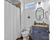Well-lit bathroom features a blue vanity with granite countertop, toilet, and a shower with white curtain at 2617 Bay St, Charlotte, NC 28205