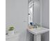 Bathroom featuring a pedestal sink, mirror, and toilet in a room with light blue walls at 2617 Bay St, Charlotte, NC 28205