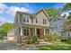Beautifully landscaped two-story home with a covered front porch, lush lawn, and a detached garage at 2617 Bay St, Charlotte, NC 28205