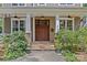 Close up of a charming front porch with stone accents, white columns, and a beautifully crafted wooden front door at 2617 Bay St, Charlotte, NC 28205