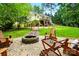 A beautiful backyard boasts a stone fire pit and green landscaping at 2745 Stockwood Dr, Gastonia, NC 28056