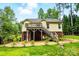 Backyard exterior view of home with a wooden deck, green trees, and a spacious yard at 2745 Stockwood Dr, Gastonia, NC 28056