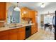 Open kitchen with wooden cabinetry, black appliances, and a view into the adjacent dining room at 2745 Stockwood Dr, Gastonia, NC 28056