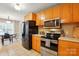 Updated kitchen with stainless steel appliances, wood cabinets, and tile flooring at 2745 Stockwood Dr, Gastonia, NC 28056