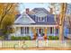 Charming two-story home featuring a welcoming porch, white picket fence, and colorful fall decor for seasonal appeal at 290 Union S St, Concord, NC 28025