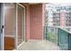 Private balcony with brick detailing and green railing overlooking the building exterior at 300 W 5Th St # 404, Charlotte, NC 28202
