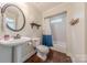 Bright bathroom featuring pedestal sink, decorative mirror, and shower with tiled walls and glass doors at 3304 Danhill Pl, Matthews, NC 28105