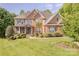 Charming two-story red brick home with lush landscaping and a welcoming front porch at 3304 Danhill Pl, Matthews, NC 28105