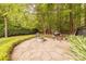 Backyard stone patio with a fire pit, grill, and seating, perfect for outdoor entertaining at 3304 Danhill Pl, Matthews, NC 28105