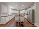 Bright kitchen features white cabinetry, a center island with seating, and modern stainless steel appliances at 3304 Danhill Pl, Matthews, NC 28105